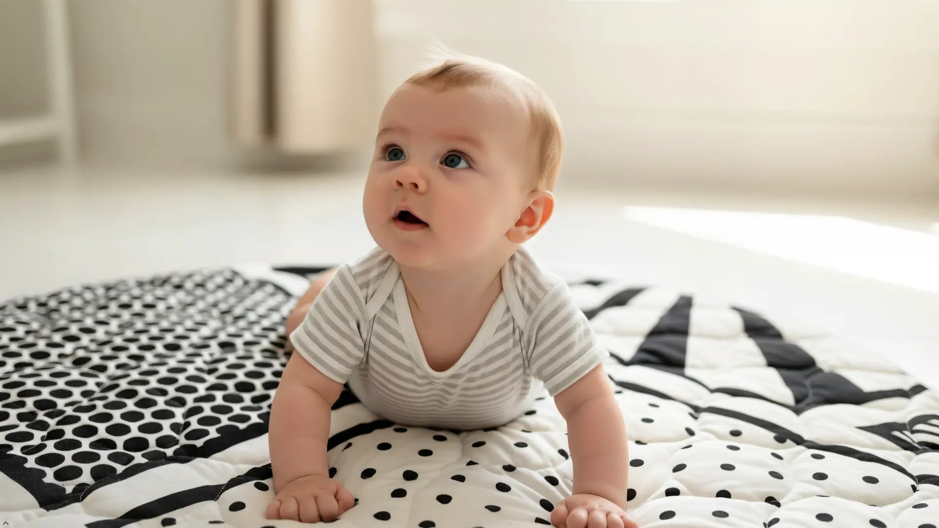 Baby sitting on a patterned blanket in a room with neutral colors