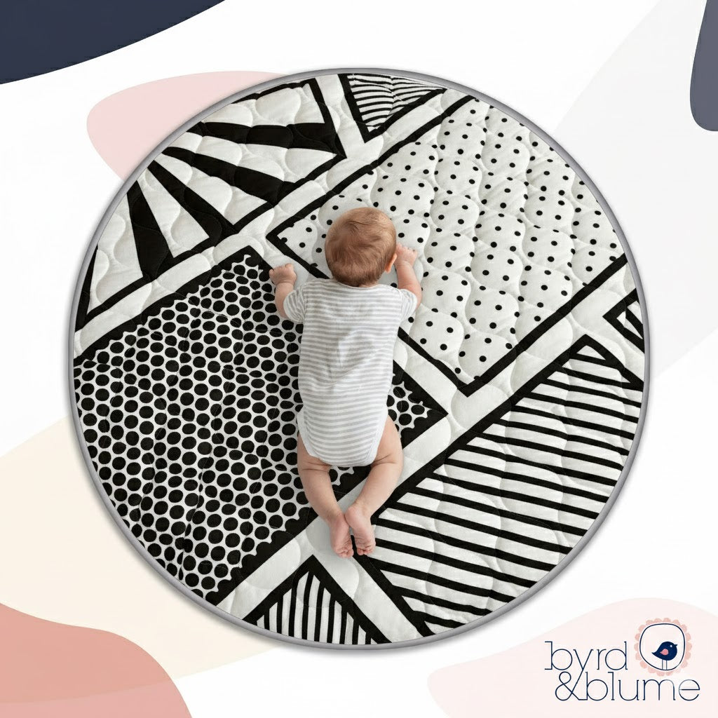 Round black and white patterned rug with a child standing on it, branded 'byrd & blume'.